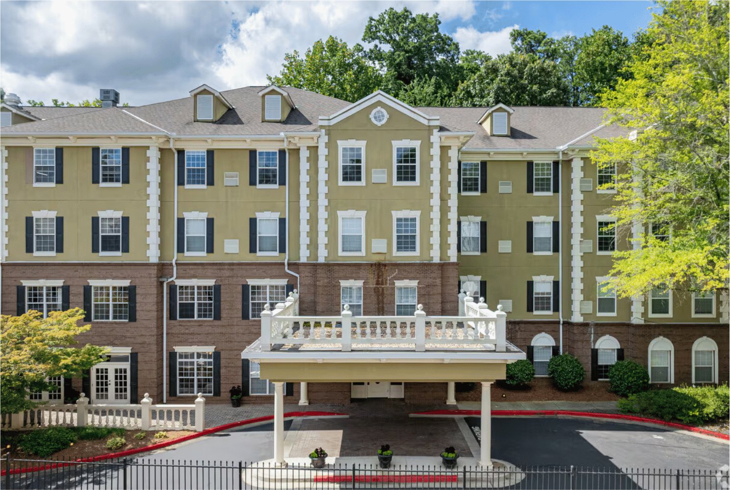 A low-rise senior living community with a covered entrance and landscaped grounds.