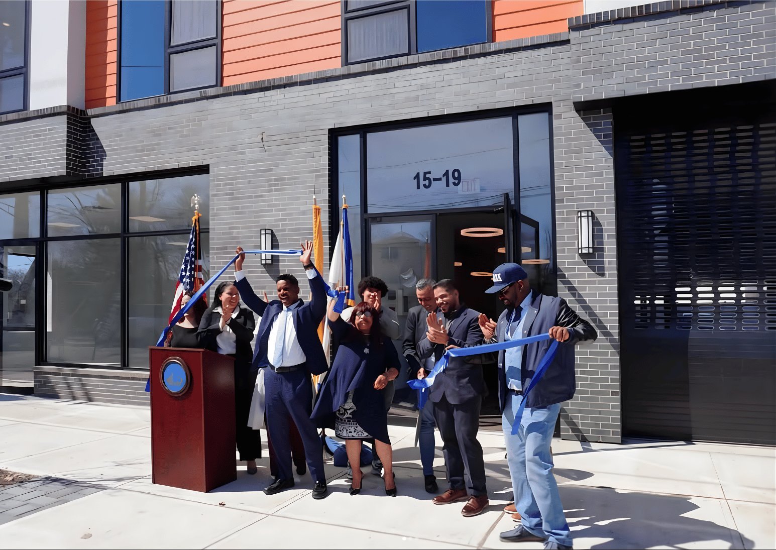 A group of people standing together outside a building entrance.